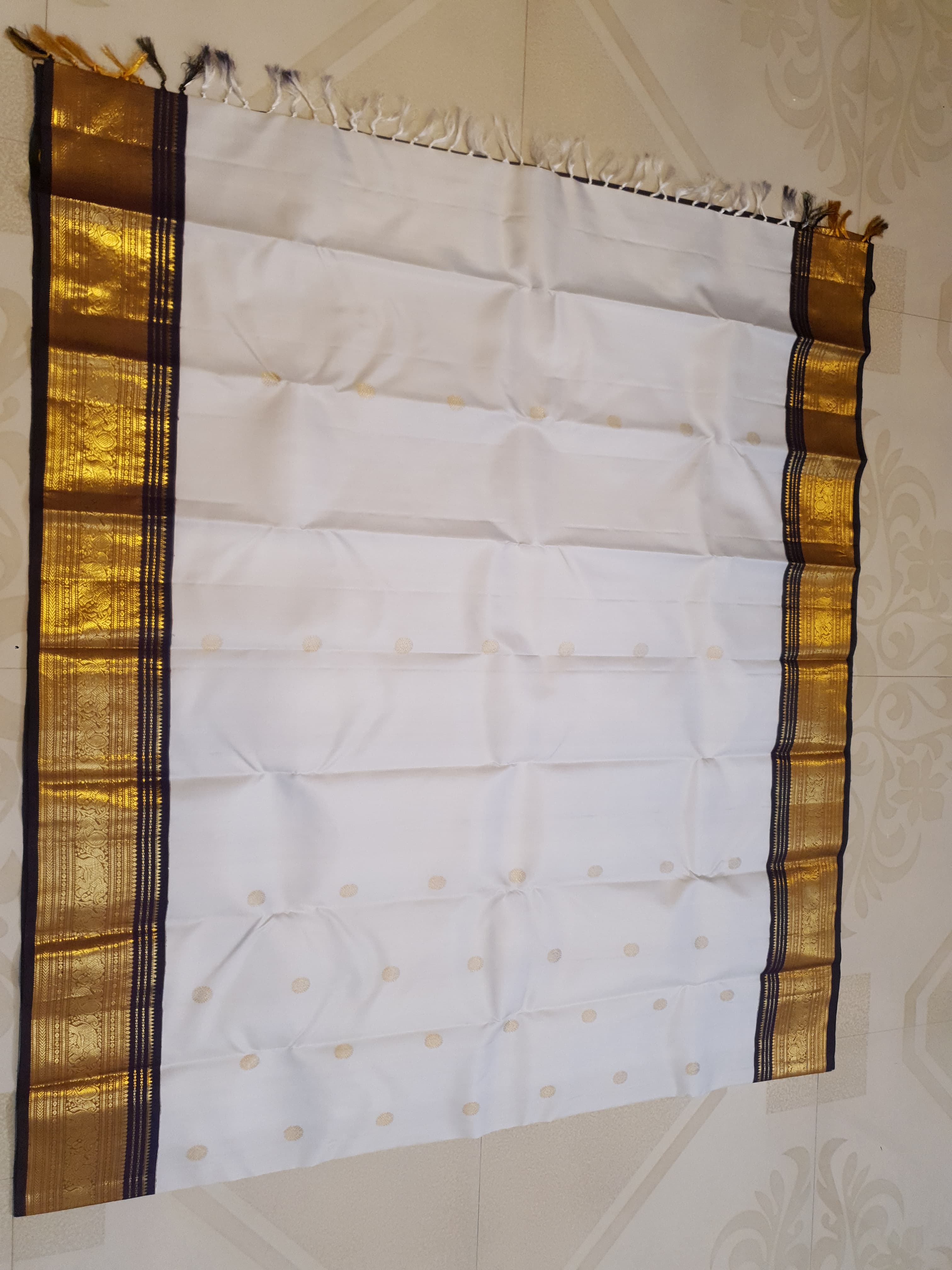 Cream Kanchipuram handloom 2G gold korvai silk saree showcasing a rich dark border and intricate gold zari motifs.