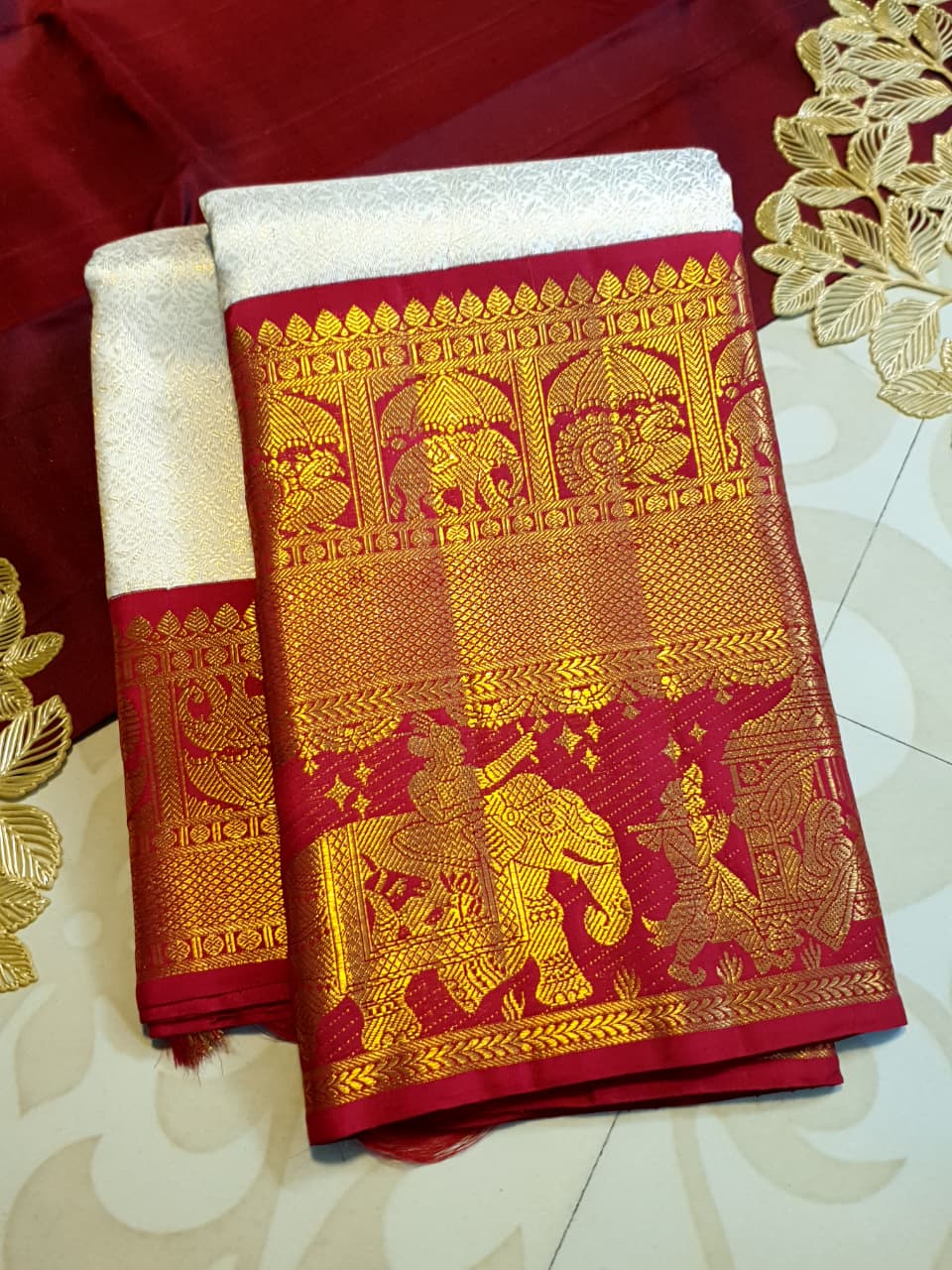 Cream Kanchipuram handloom silk saree with a vibrant pink and gold border, featuring intricate Kalyana Pallakku zari work, accessorized with traditional gold jewelry.
