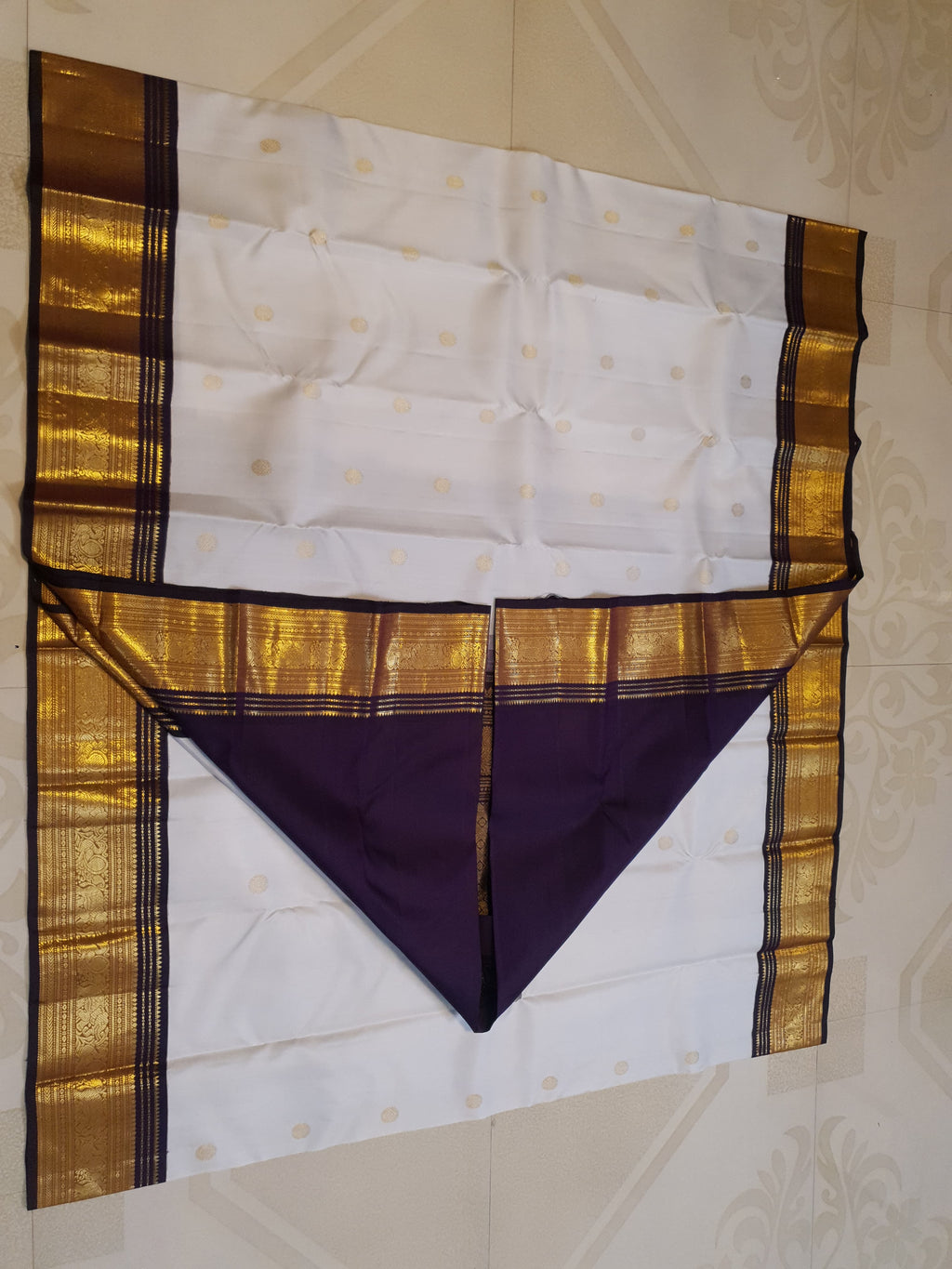 Cream Kanchipuram handloom 2G gold korvai silk saree showcasing a rich dark border and intricate gold zari motifs.