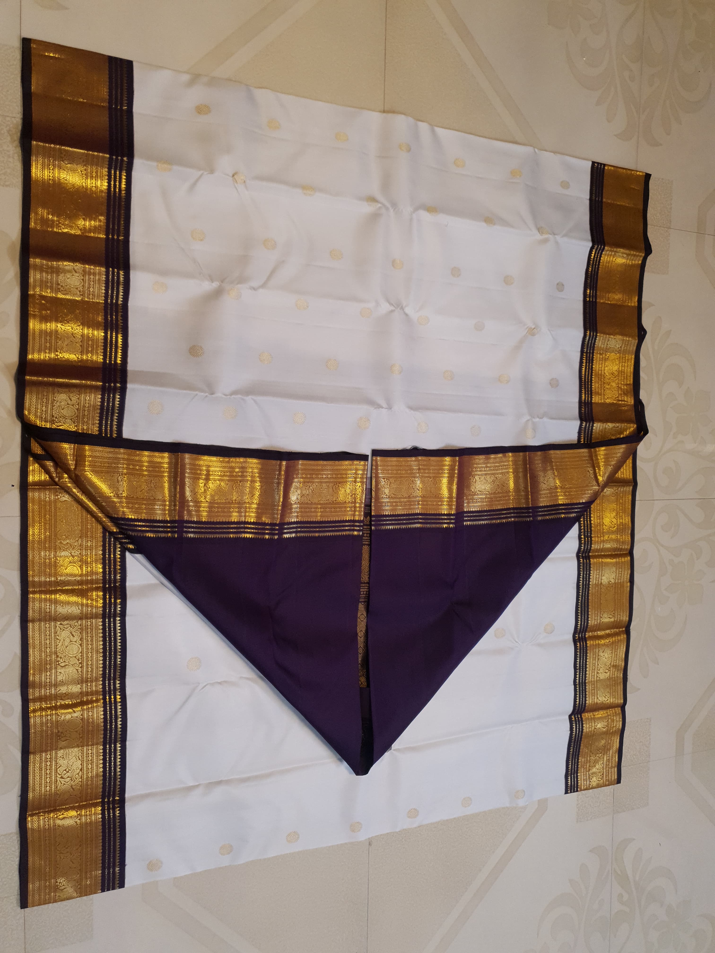 Cream Kanchipuram handloom 2G gold korvai silk saree showcasing a rich dark border and intricate gold zari motifs.