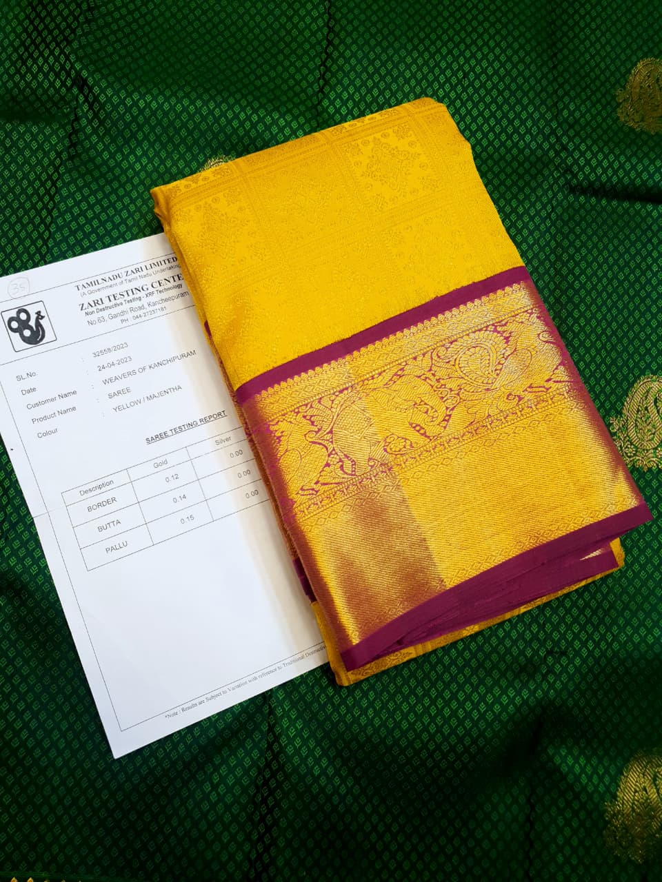 Traditional golden yellow Kanchipuram handloom 2G gold pattu silk saree with a rich magenta and zari woven border in a festive setting.