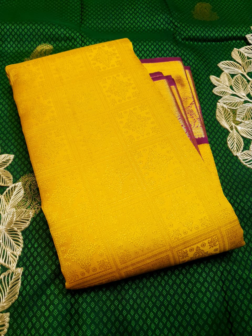 Traditional golden yellow Kanchipuram handloom 2G gold pattu silk saree with a rich magenta and zari woven border in a festive setting.