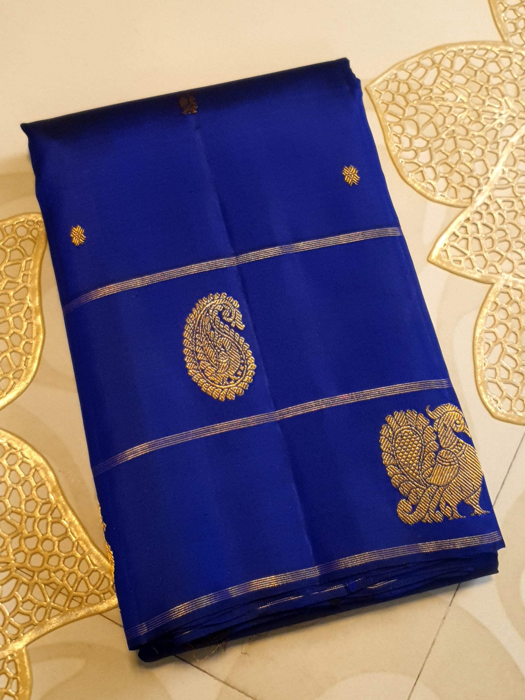 Royal Blue Kanchipuram handloom pattu silk saree featuring intricate 2G gold paisley and peacock motifs, classic gold zari borders, and a certified silk mark weave.