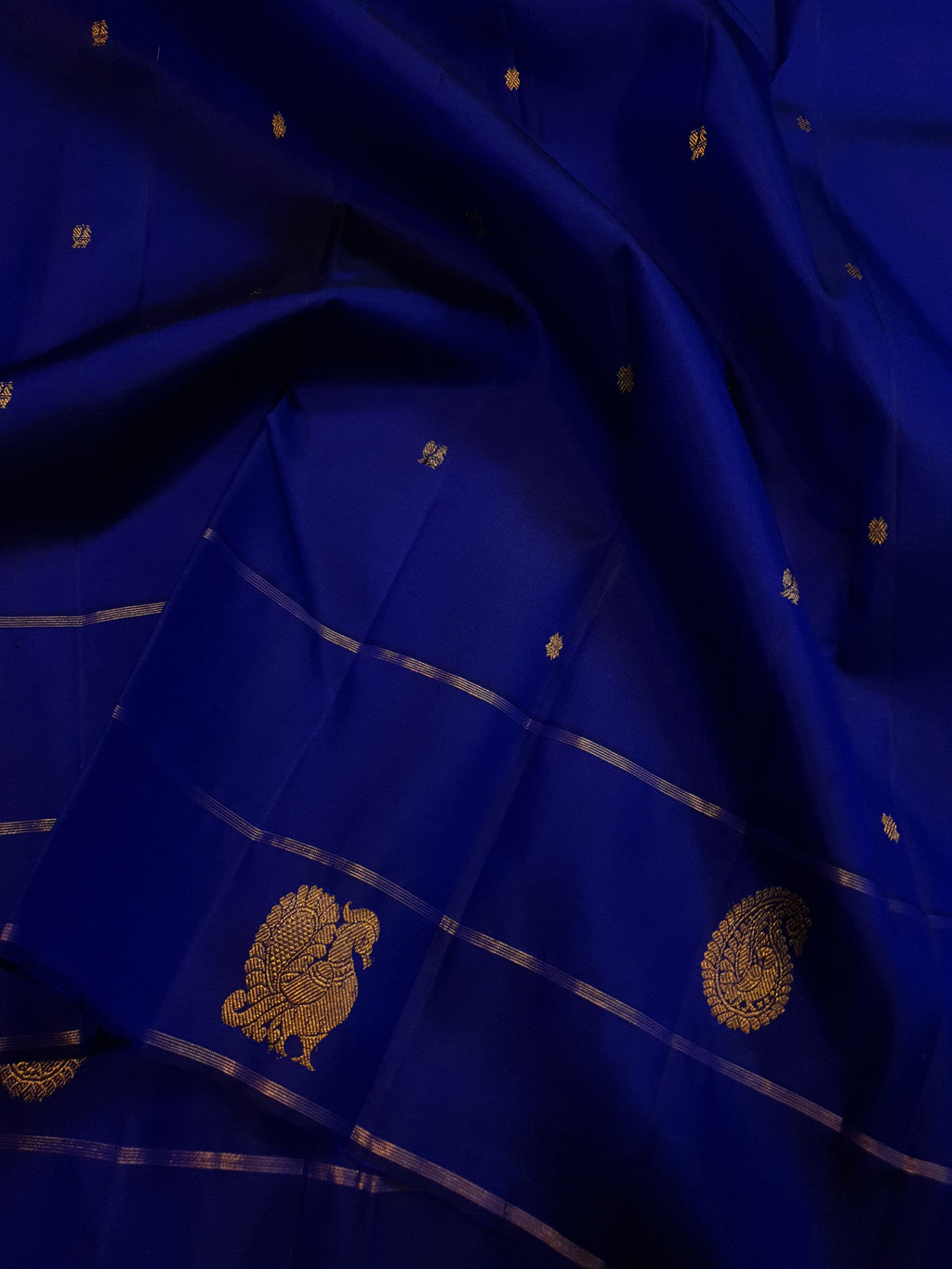 Royal Blue Kanchipuram handloom pattu silk saree featuring intricate 2G gold paisley and peacock motifs, classic gold zari borders, and a certified silk mark weave.