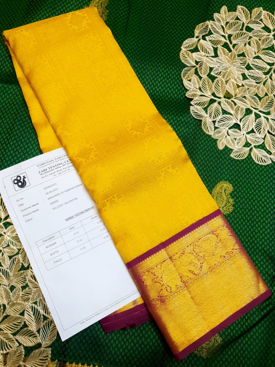 Traditional golden yellow Kanchipuram handloom 2G gold pattu silk saree with a rich magenta and zari woven border in a festive setting.