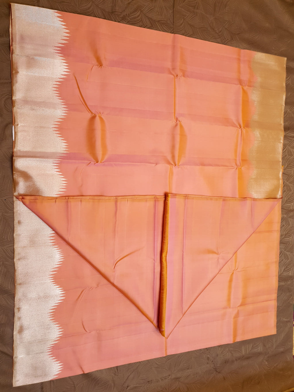 Coral Kanchipuram handloom silk saree featuring a detailed silver zari temple border and luxurious silver accents.