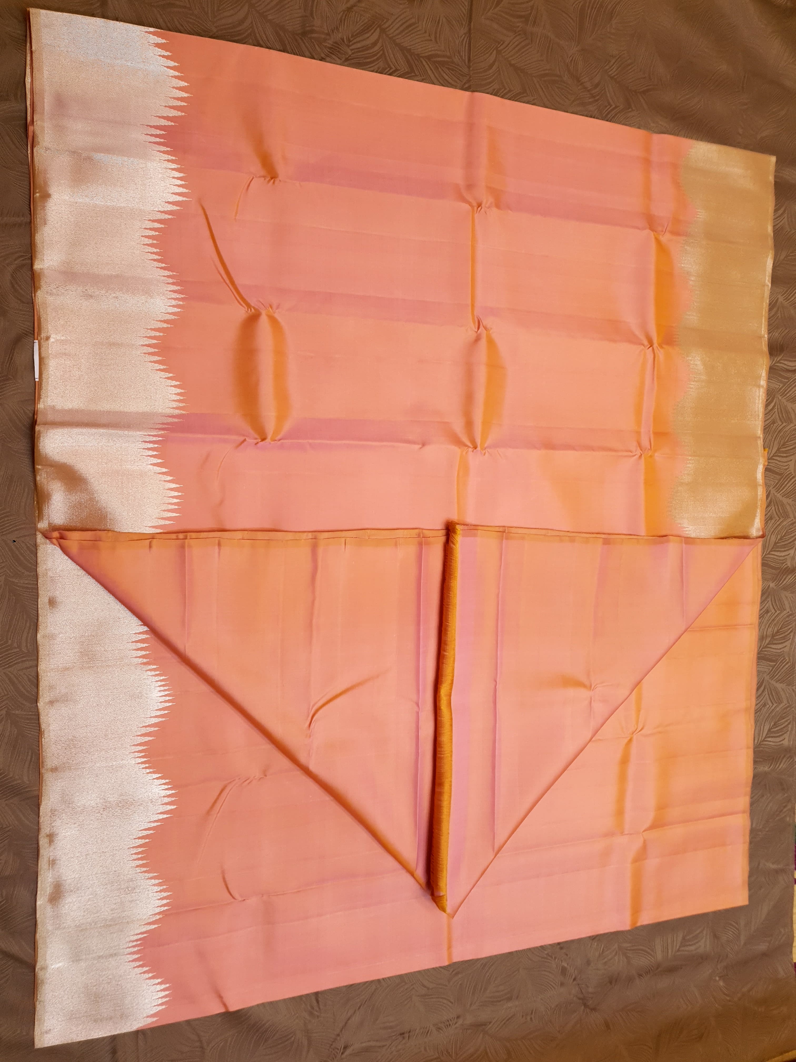 Coral Kanchipuram handloom silk saree featuring a detailed silver zari temple border and luxurious silver accents.