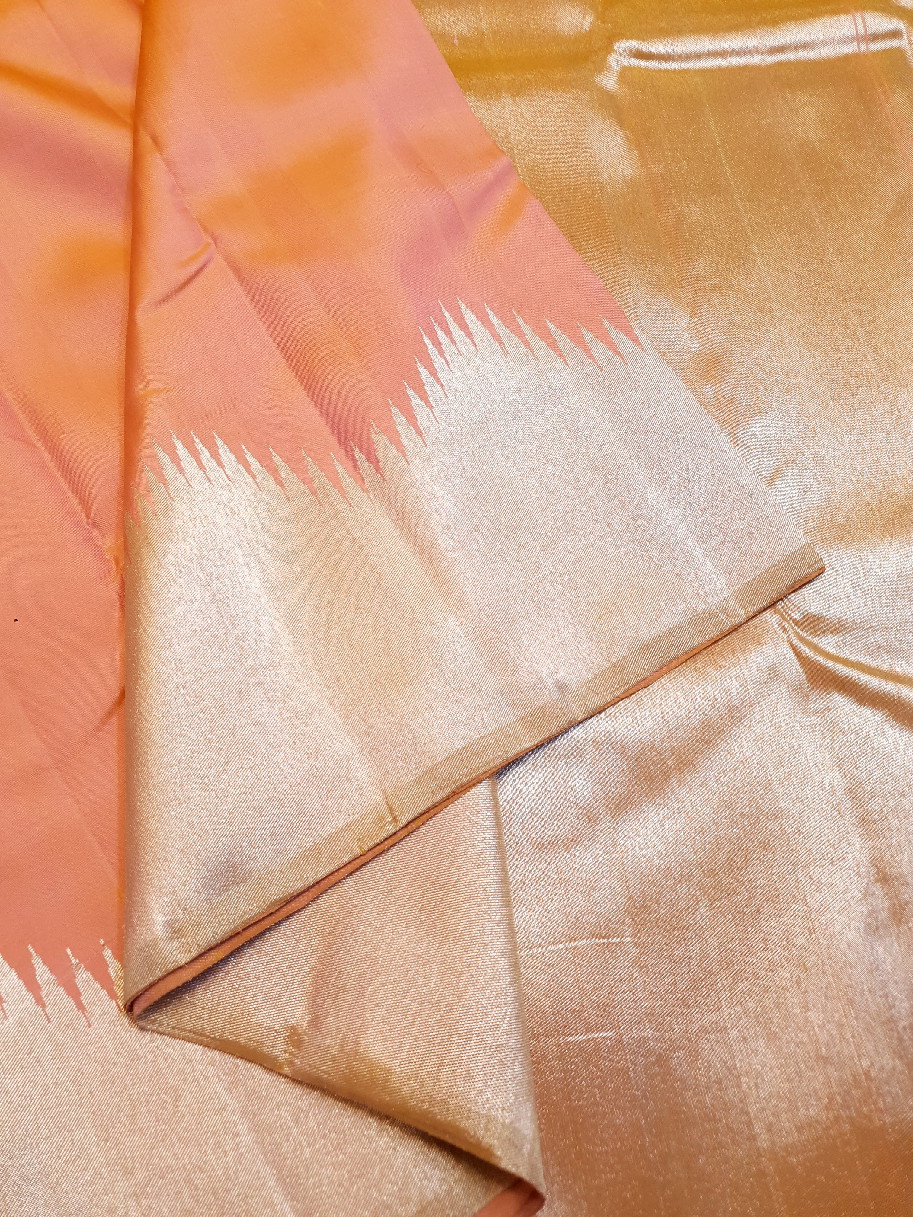 Coral Kanchipuram handloom silk saree featuring a detailed silver zari temple border and luxurious silver accents.