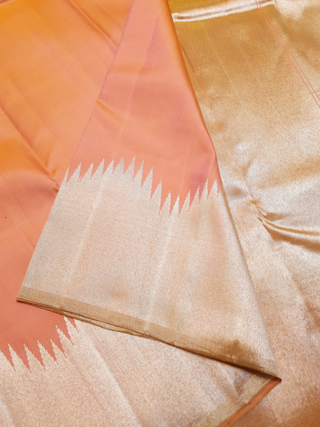 Coral Kanchipuram handloom silk saree featuring a detailed silver zari temple border and luxurious silver accents.