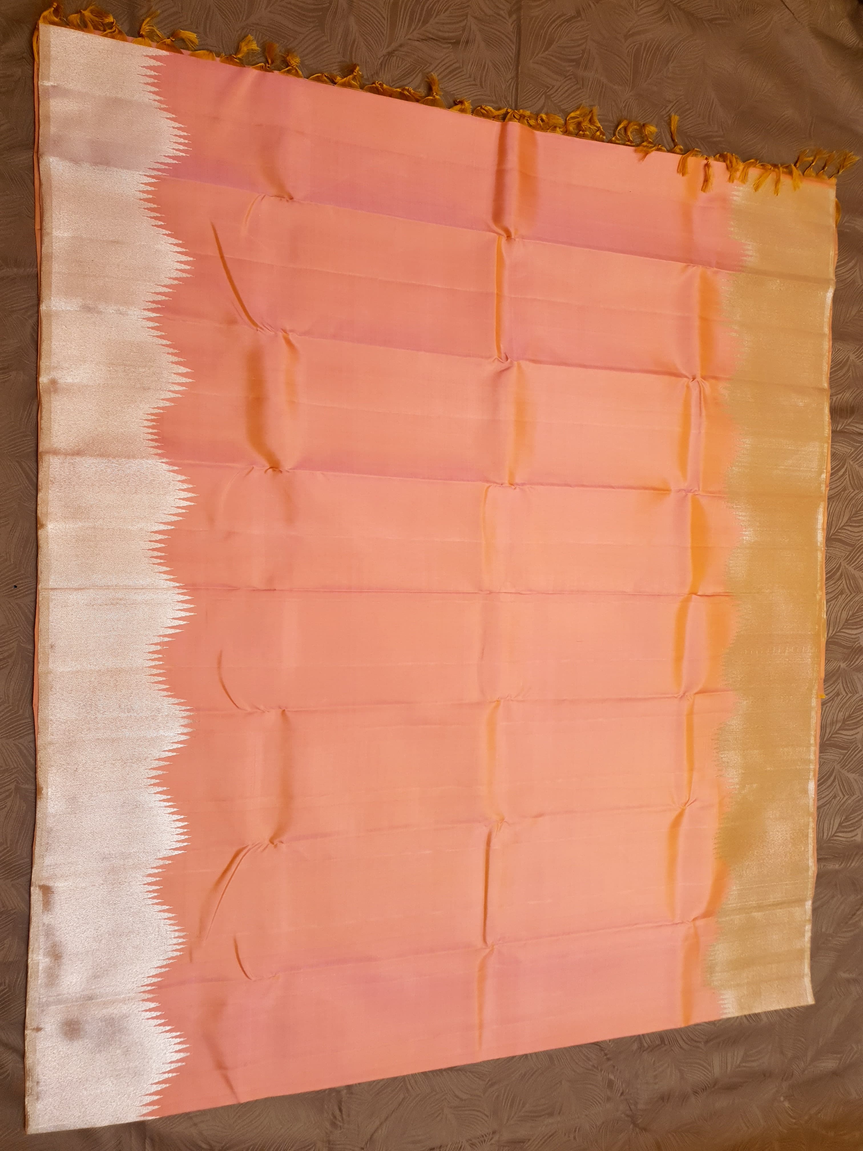 Coral Kanchipuram handloom silk saree featuring a detailed silver zari temple border and luxurious silver accents.