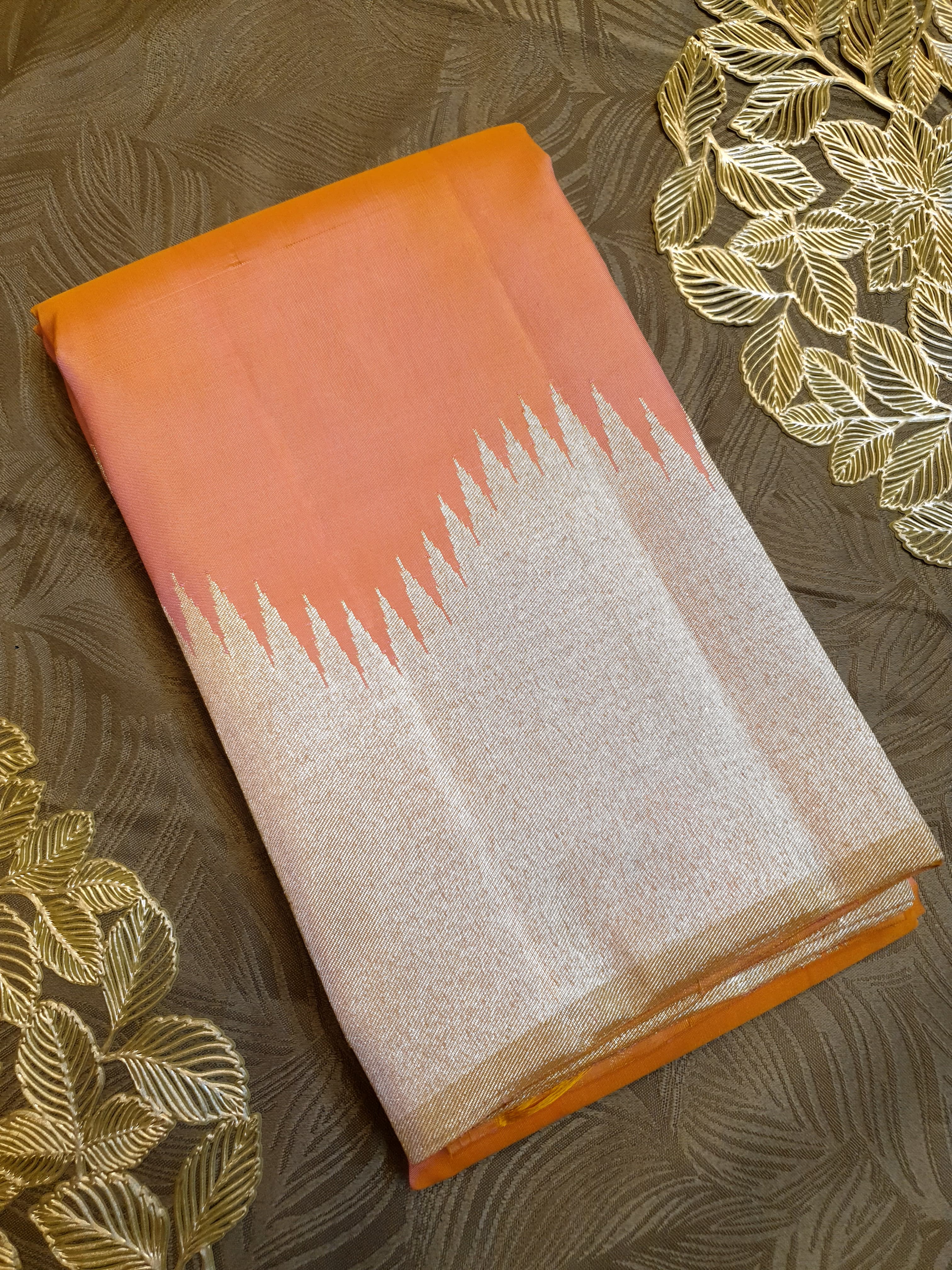 Coral Kanchipuram handloom silk saree featuring a detailed silver zari temple border and luxurious silver accents.