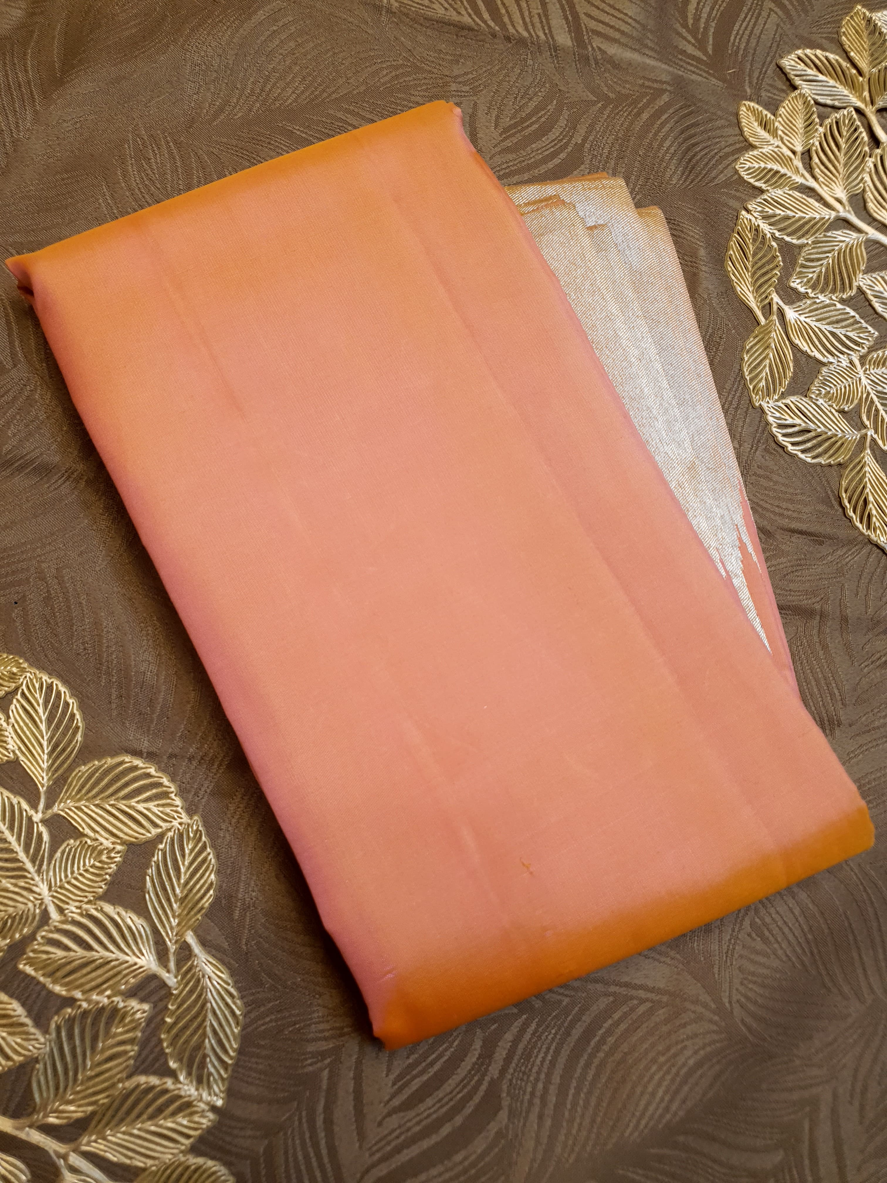 Coral Kanchipuram handloom silk saree featuring a detailed silver zari temple border and luxurious silver accents.