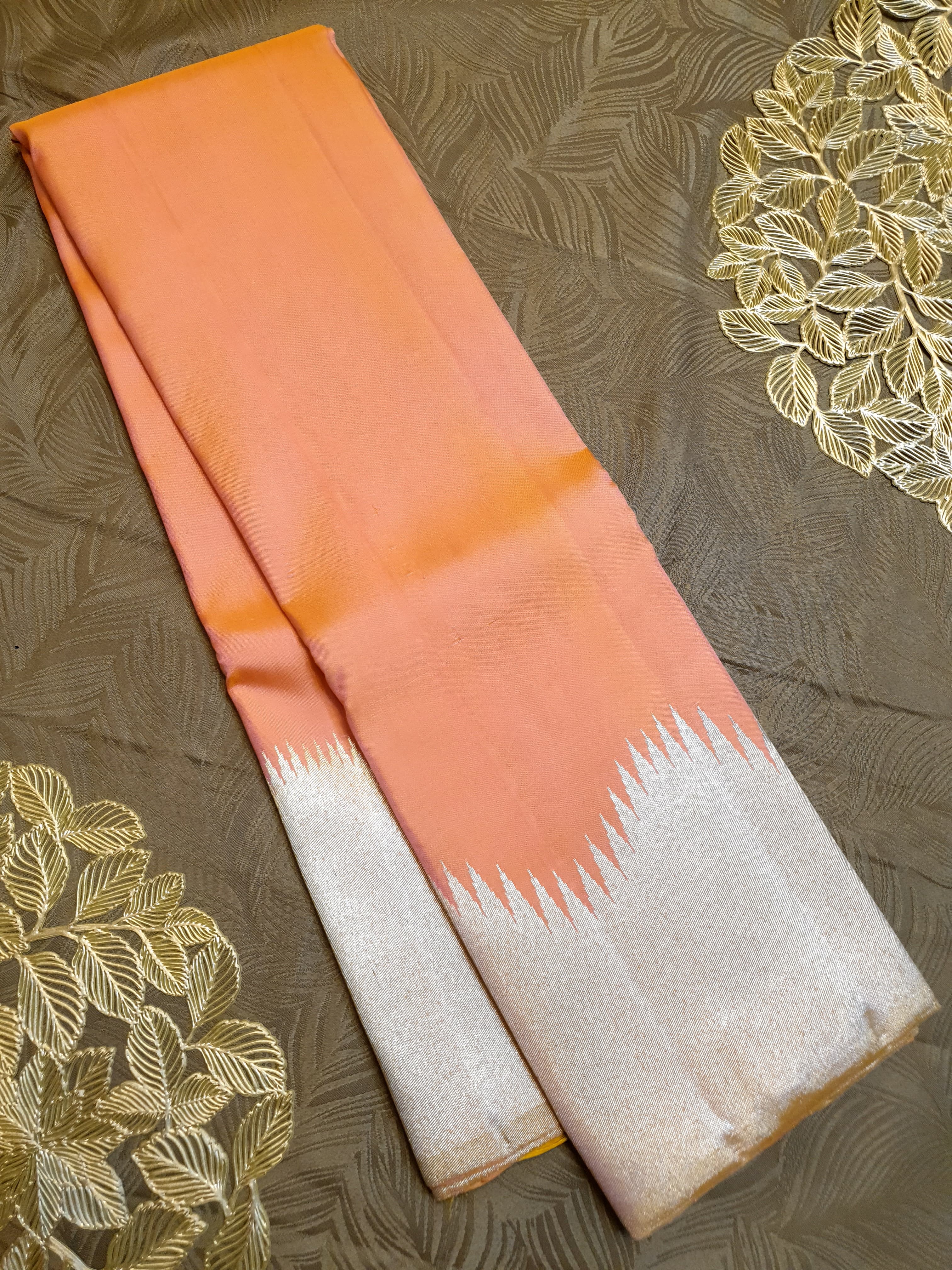 Coral Kanchipuram handloom silk saree featuring a detailed silver zari temple border and luxurious silver accents.