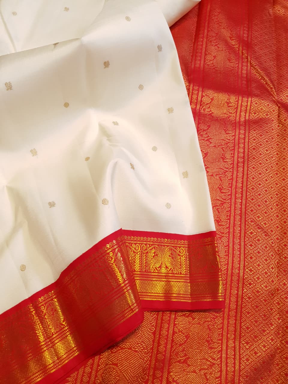Off White Kanchipuram Handloom Silk Saree featuring Mayil Chakram motifs, contrast red borders, and a matching red pallu and blouse.