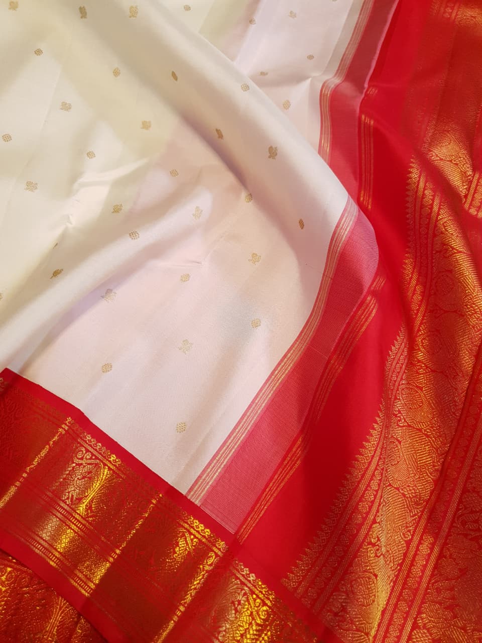 Off White Kanchipuram Handloom Silk Saree featuring Mayil Chakram motifs, contrast red borders, and a matching red pallu and blouse.