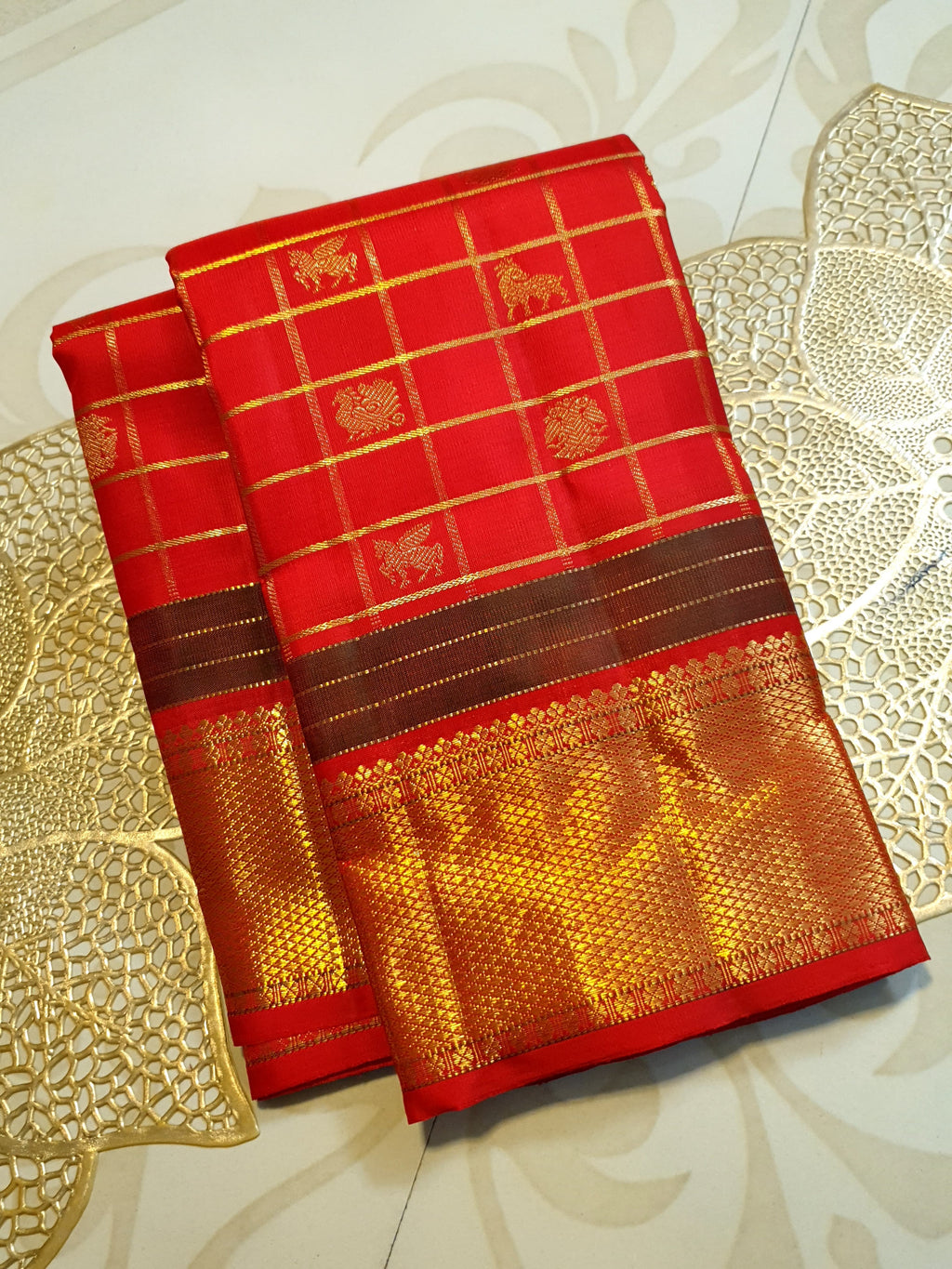 Rustic red Kanchipuram handloom silk saree featuring 3G pure gold zari checks, traditional buttas, and a rich woven border.