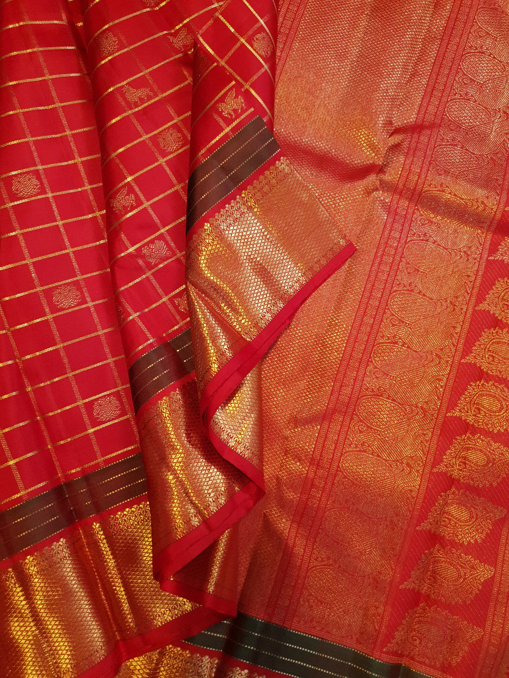 Rustic red Kanchipuram handloom silk saree featuring 3G pure gold zari checks, traditional buttas, and a rich woven border.
