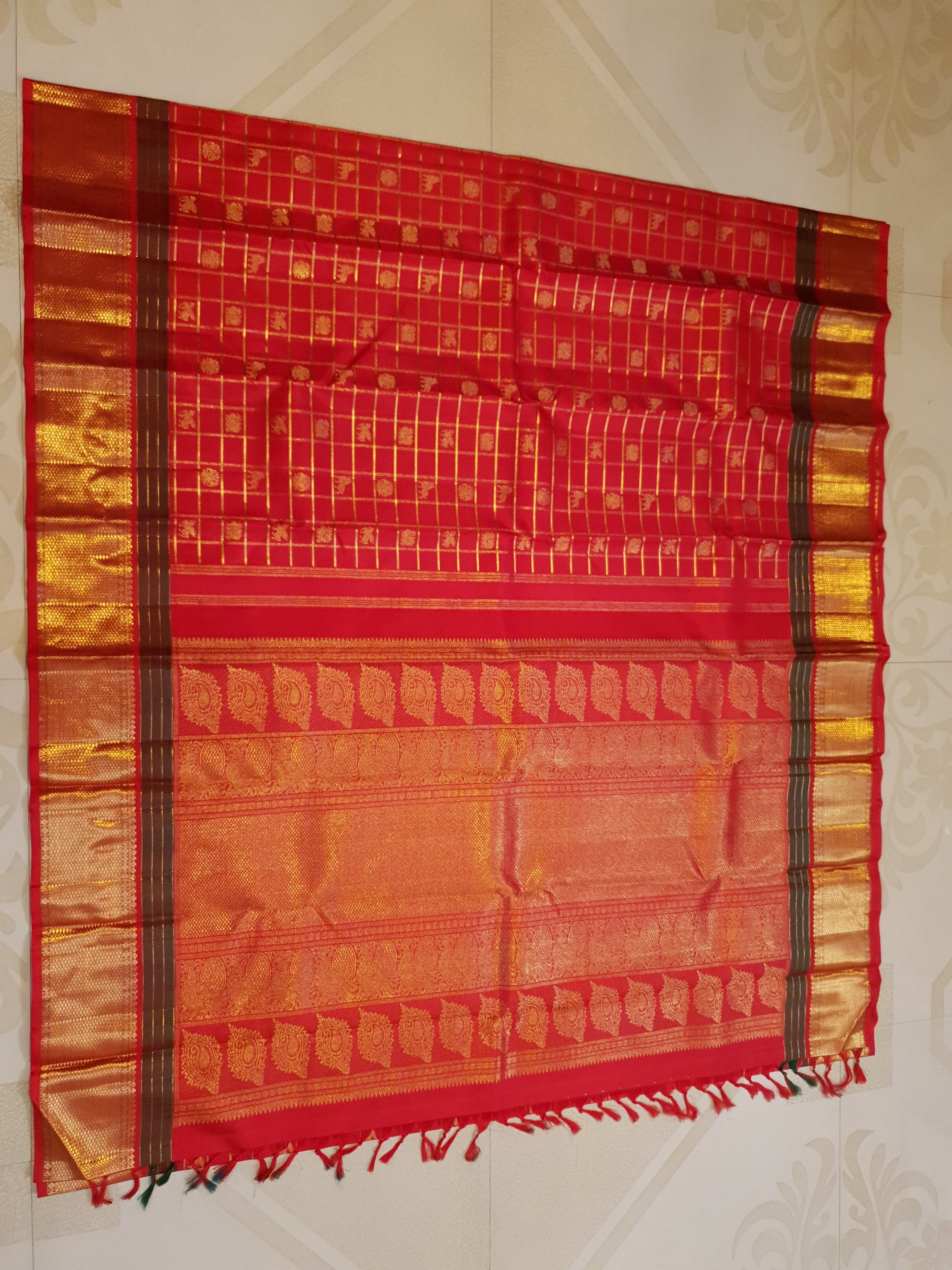 Rustic red Kanchipuram handloom silk saree featuring 3G pure gold zari checks, traditional buttas, and a rich woven border.
