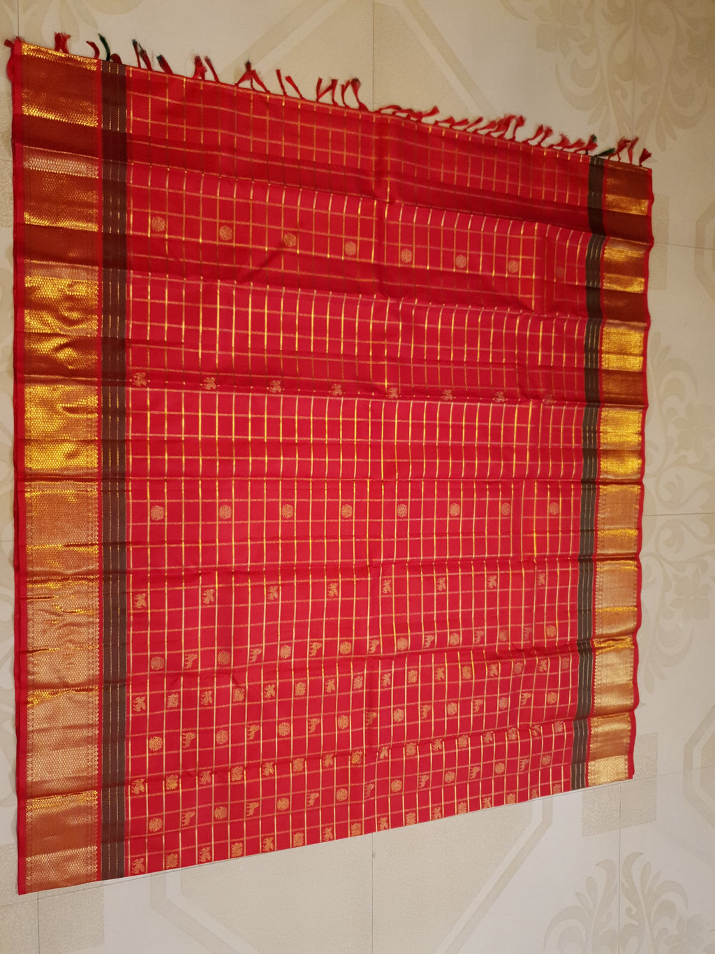 Rustic red Kanchipuram handloom silk saree featuring 3G pure gold zari checks, traditional buttas, and a rich woven border.