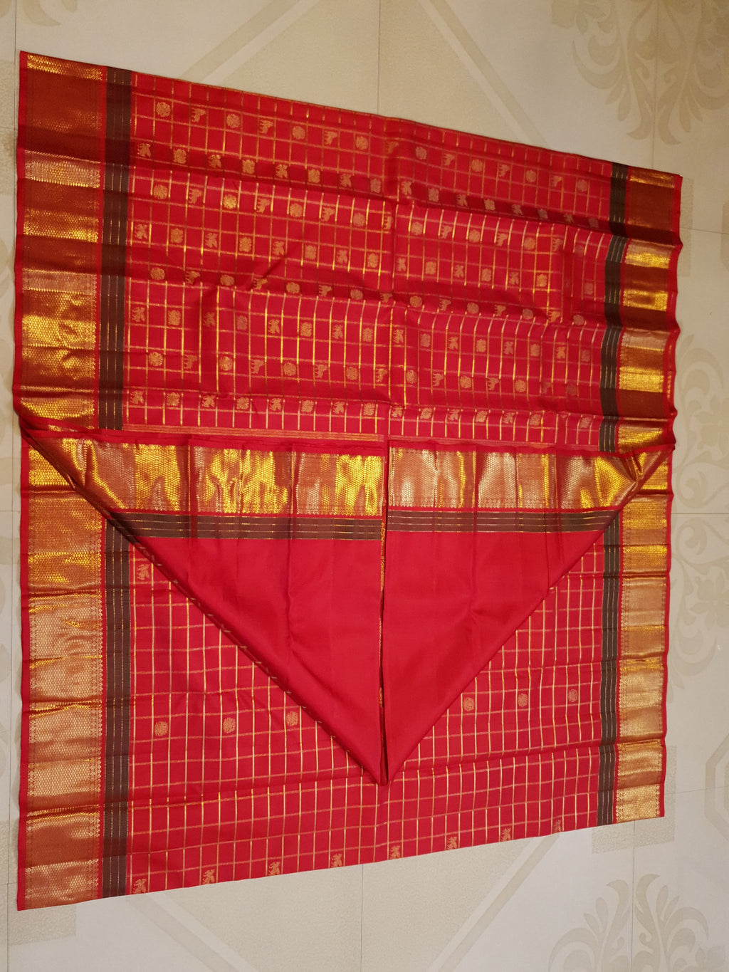 Rustic red Kanchipuram handloom silk saree featuring 3G pure gold zari checks, traditional buttas, and a rich woven border.