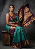 A luxurious Kanchipuram semi pattu silk bridal saree showcasing a rich textured body and a wide, bold contrast zari border with traditional temple motifs.