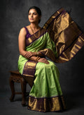 A luxurious Kanchipuram semi pattu silk bridal saree showcasing a rich textured body and a wide, bold contrast zari border with traditional temple motifs.