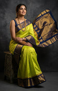 A luxurious Kanchipuram semi pattu silk bridal saree showcasing a rich textured body and a wide, bold contrast zari border with traditional temple motifs.