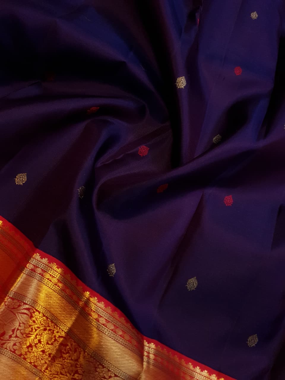 Deep Purple Kanchipuram Handloom Silk Saree with multicolored chakram motifs across the body and a wide red Korvai border featuring intricate gold zari.