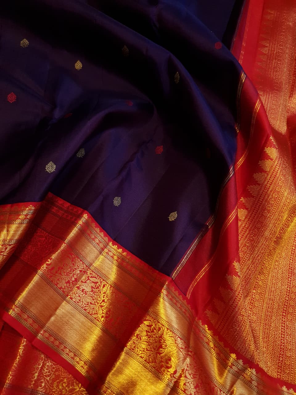 Deep Purple Kanchipuram Handloom Silk Saree with multicolored chakram motifs across the body and a wide red Korvai border featuring intricate gold zari.