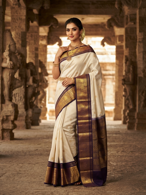 Cream Kanchipuram handloom 2G gold korvai silk saree showcasing a rich dark border and intricate gold zari motifs.