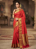 Model wearing a rustic red Kanchipuram handloom silk saree featuring 3G pure gold zari checks, traditional buttas, and a rich woven border.