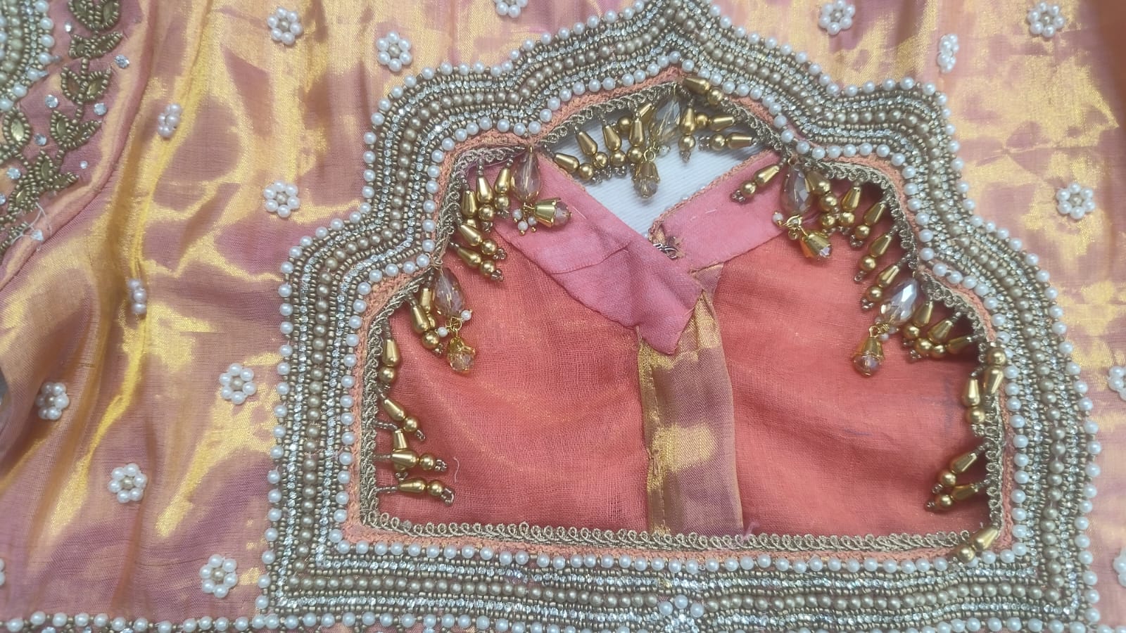 Detailed view of custom Maggham embroidery work on premium pink fabric, showcasing intricate hand-embroidered borders, leaf motifs, and beadwork on a traditional wooden embroidery frame