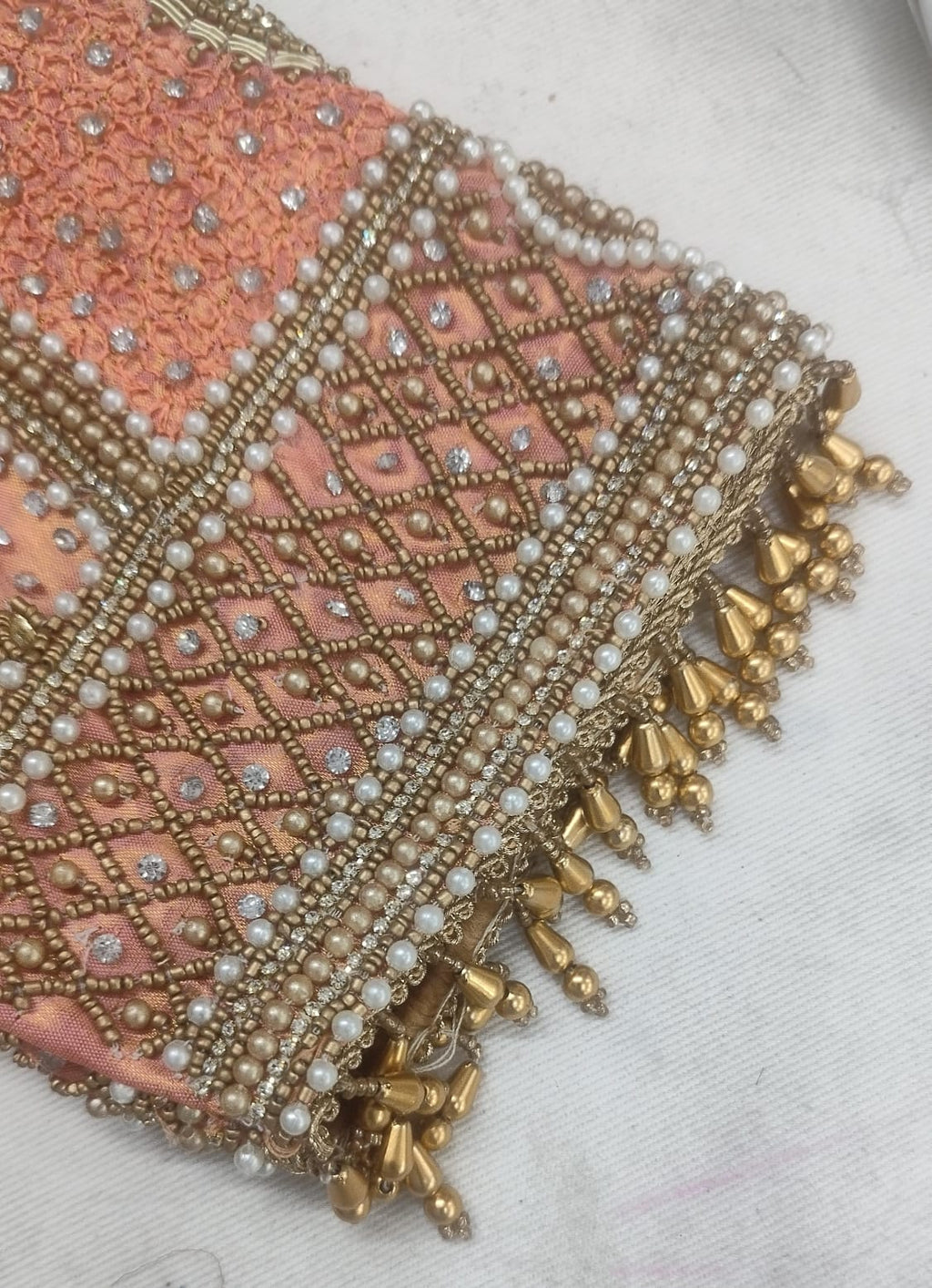 Detailed view of custom Maggham embroidery work on premium pink fabric, showcasing intricate hand-embroidered borders, leaf motifs, and beadwork on a traditional wooden embroidery frame