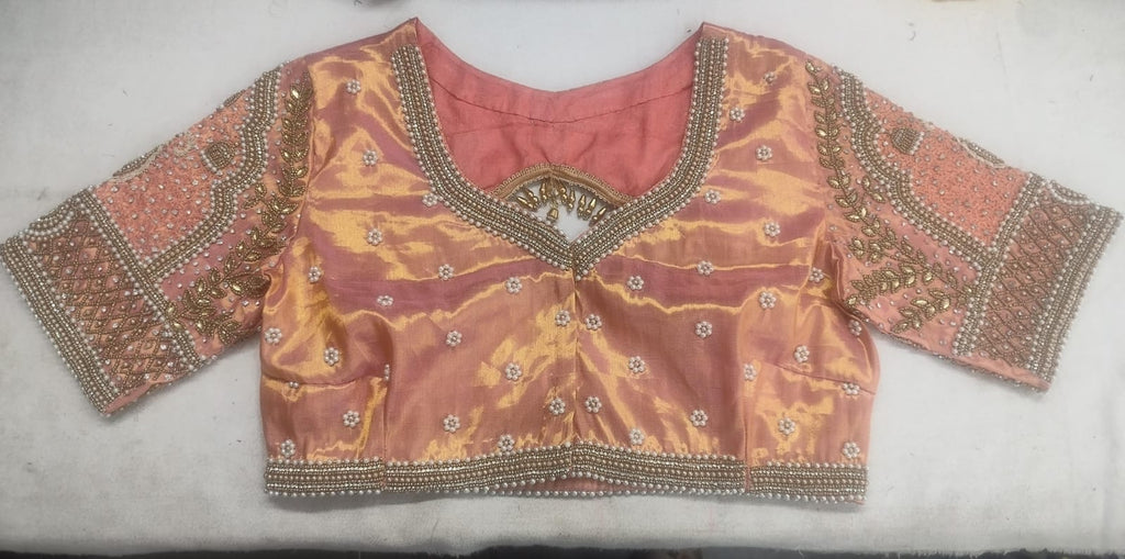 Detailed view of custom Maggham embroidery work on premium pink fabric, showcasing intricate hand-embroidered borders, leaf motifs, and beadwork on a traditional wooden embroidery frame