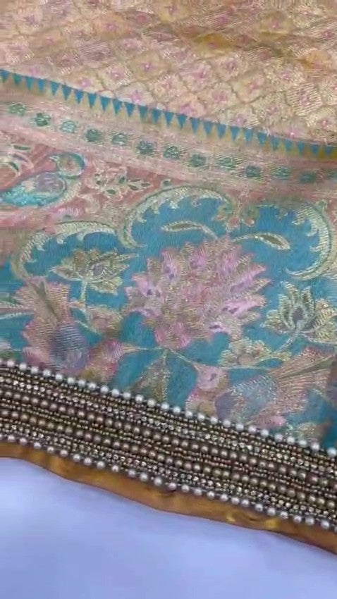 Detailed view of custom Maggham embroidery work on premium pink fabric, showcasing intricate hand-embroidered borders, leaf motifs, and beadwork on a traditional wooden embroidery frame