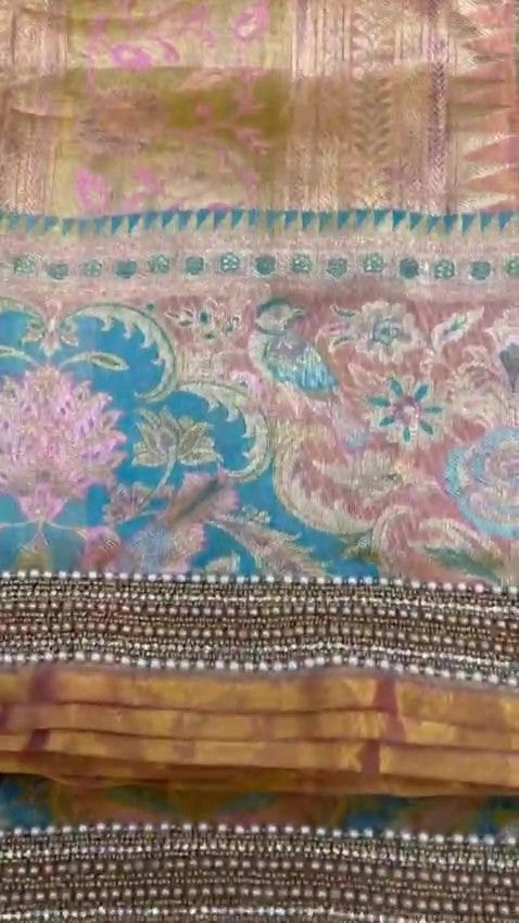 Detailed view of custom Maggham embroidery work on premium pink fabric, showcasing intricate hand-embroidered borders, leaf motifs, and beadwork on a traditional wooden embroidery frame