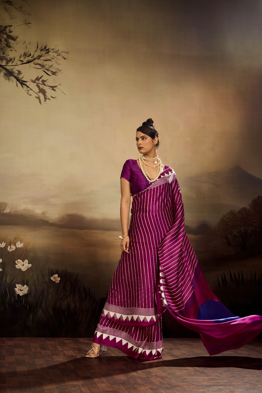 A vibrant magenta modal silk saree with white vertical pinstripes, a large royal blue circular design on the pallu, and a matching patterned blouse piece.