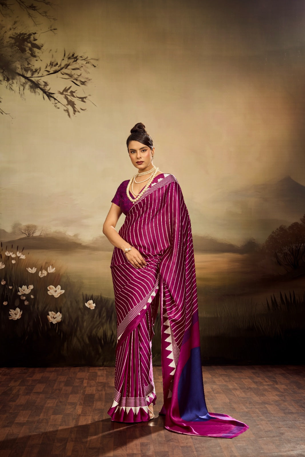 A vibrant magenta modal silk saree with white vertical pinstripes, a large royal blue circular design on the pallu, and a matching patterned blouse piece.