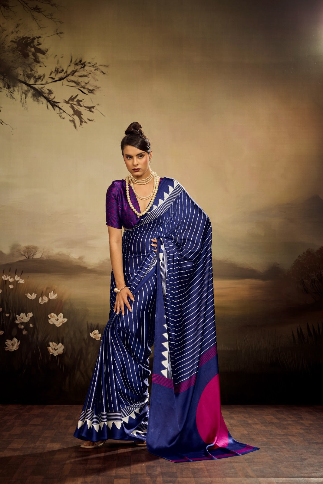 Midnight blue modal silk saree with white vertical pinstripes, a large bright pink circular design on the pallu, and a white sawtooth geometric border.