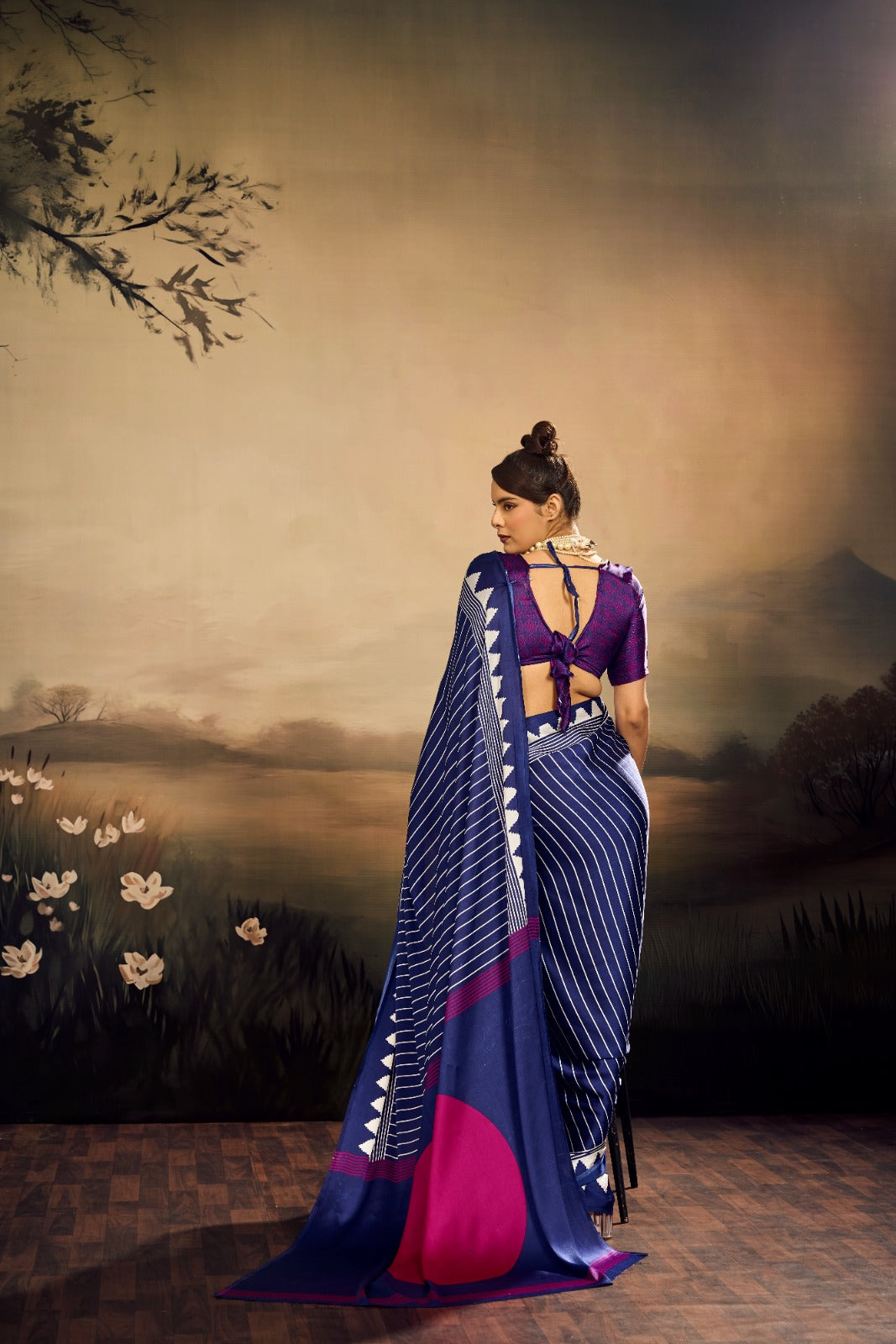 Midnight blue modal silk saree with white vertical pinstripes, a large bright pink circular design on the pallu, and a white sawtooth geometric border.