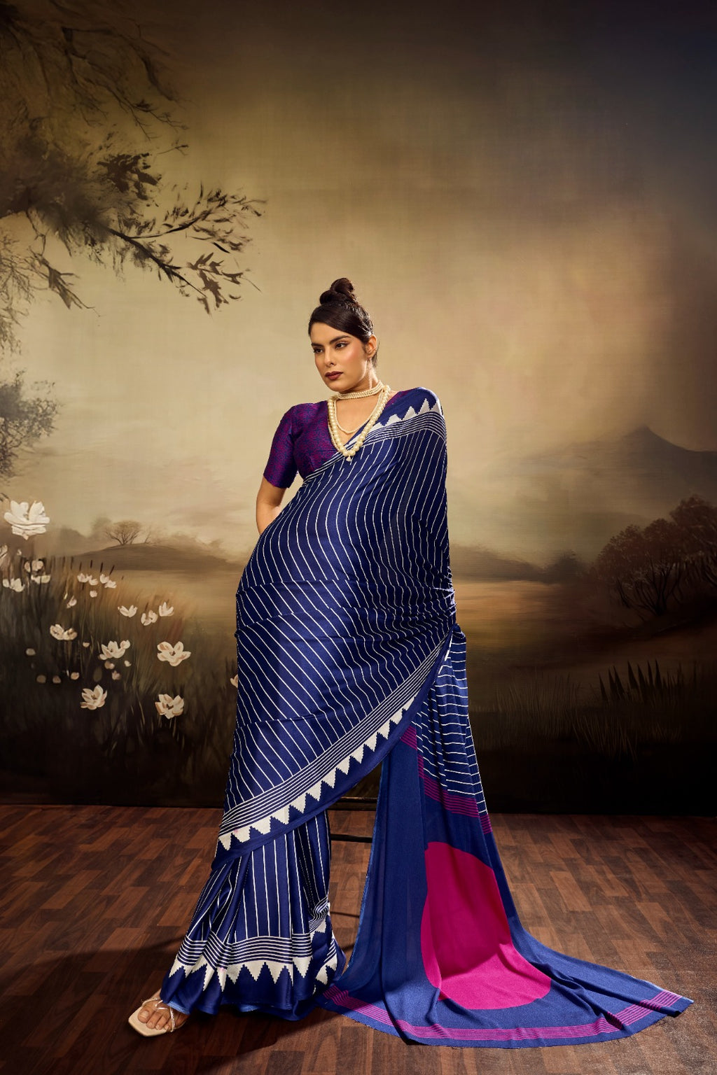 Midnight blue modal silk saree with white vertical pinstripes, a large bright pink circular design on the pallu, and a white sawtooth geometric border.