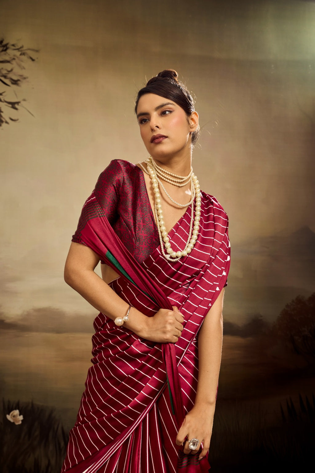 A maroon modal silk saree featuring uniform white vertical stripes, a solid green circular accent on the pallu, and a sharp white triangular border.
