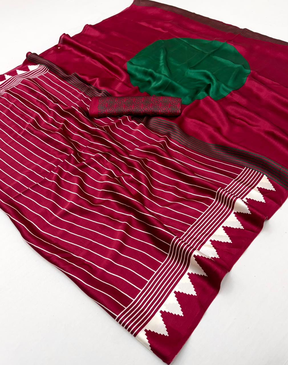 A maroon modal silk saree featuring uniform white vertical stripes, a solid green circular accent on the pallu, and a sharp white triangular border.