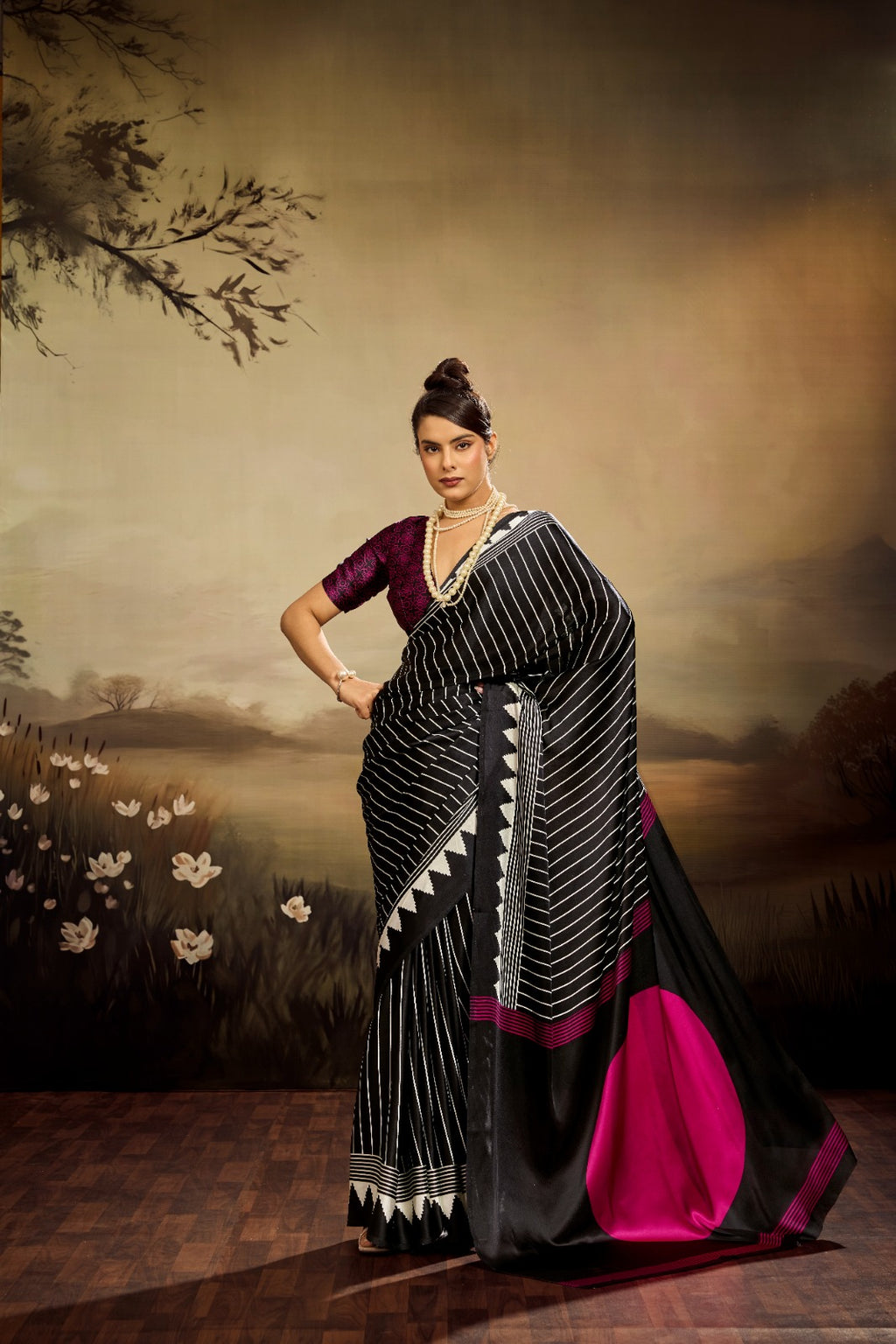 Jet black modal silk saree with white vertical pinstripes, a large bright pink circular motif on the pallu, and a matching patterned blouse piece.