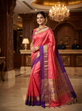 Model wearing a Coral Pink Kanchipuram Handloom 2G Gold Korvai Silk Saree with rich purple and gold zari borders and traditional motifs.