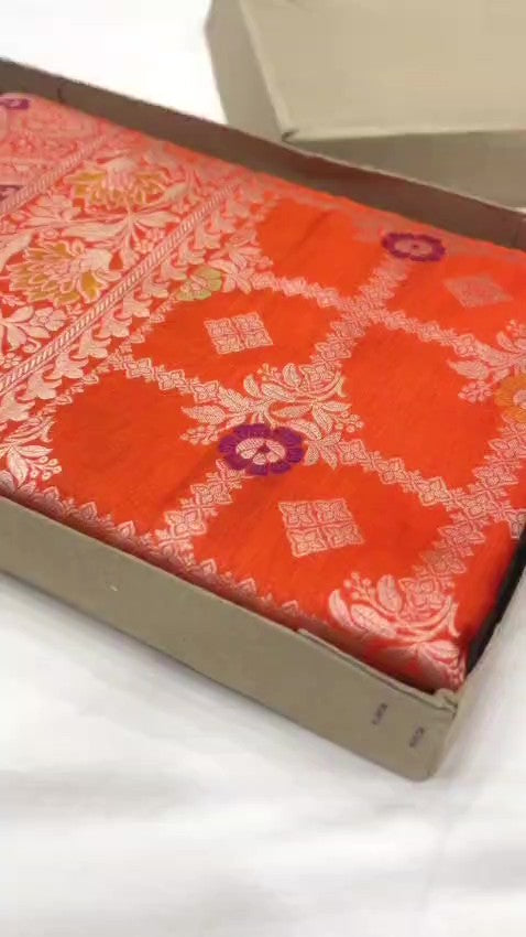 A vibrant orange handloom Banarasi Katan silk saree with an intricate all-over grid pattern and multicolored Meenakari floral motifs, featuring a heavy gold zari border and pallu.