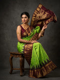Parrot green Pochampally handloom ikat silk saree with Silk Mark certification, featuring a rich maroon border, intricate zari work, and traditional motifs.