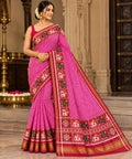 Model wearing a dark pink Patan Patola pure mulberry silk saree featuring a body with lehriya design and contrasting red borders and pallu with elephant motifs.