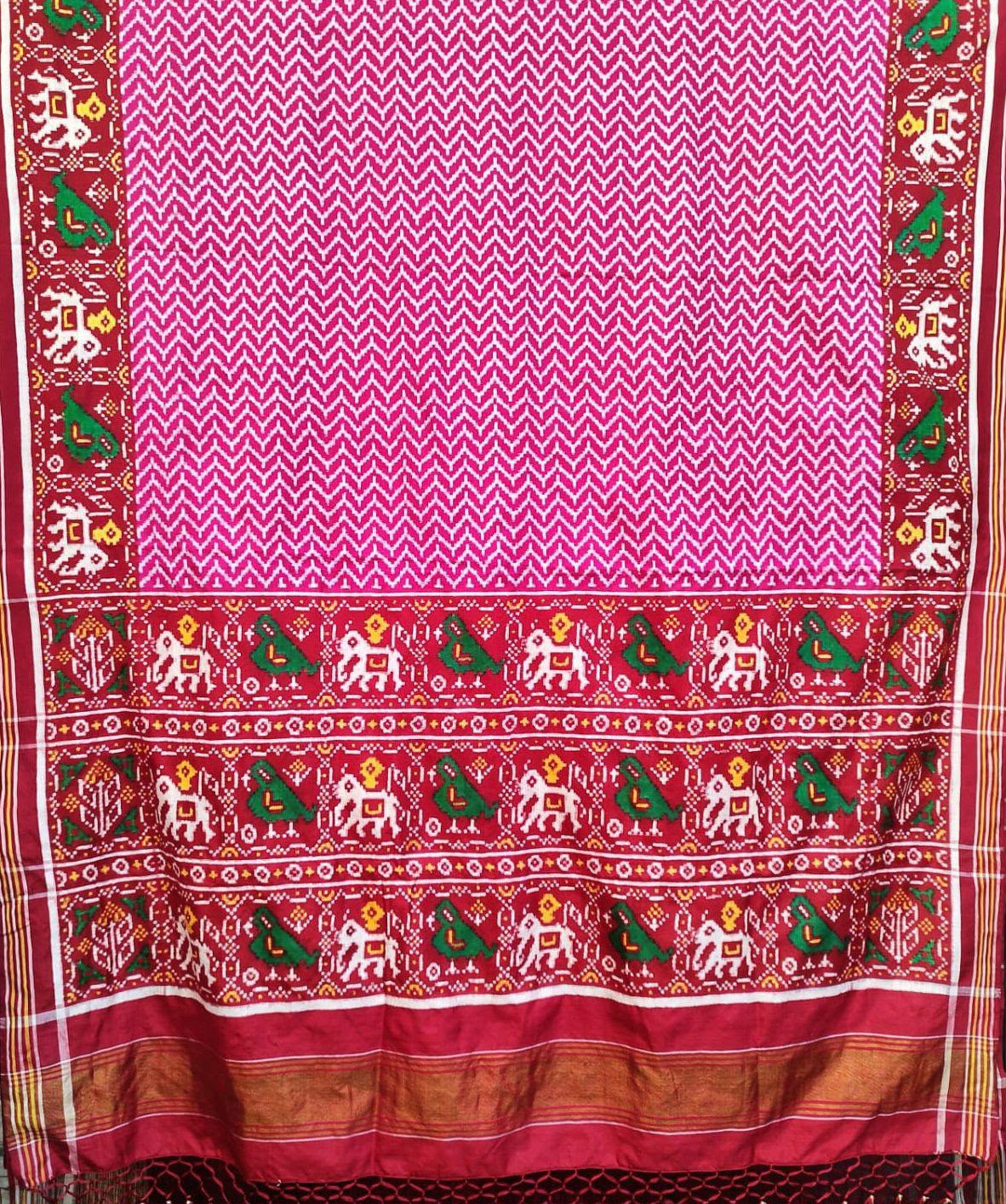 Model wearing a dark pink Patan Patola pure mulberry silk saree featuring a body with lehriya design and contrasting red borders and pallu with elephant motifs.