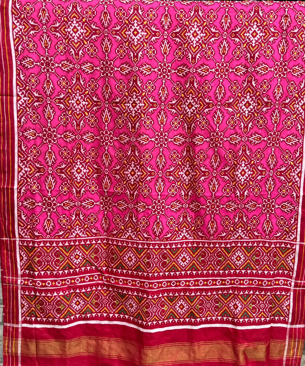 Dark pink Patan Patola pure mulberry silk saree featuring an intricate geometric double ikat lattice design with a matching patterned pallu and traditional borders.